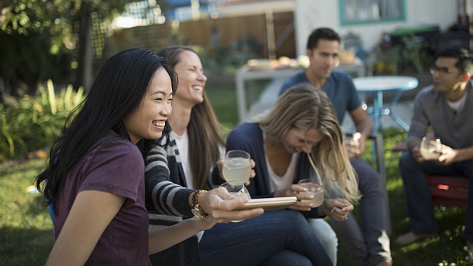 Vrouwen drinken limonade en lachen tijdens een barbecue in de achtertuin