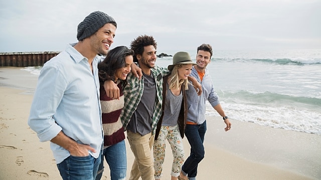 Gruppe von Freunden, die am Strand spazieren gehen
