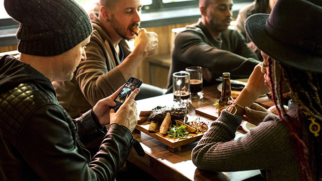 Gruppe von Freunden, die zusammen ein Steak zu Abend essen